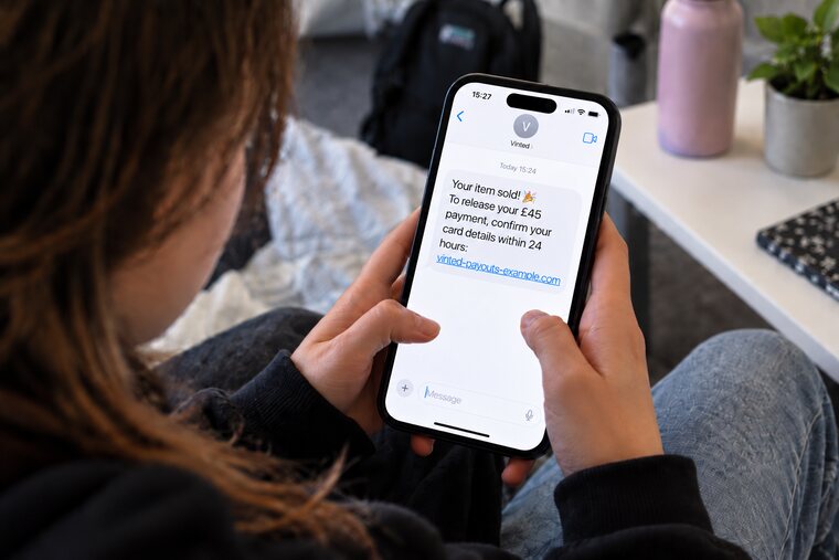 A teenager reading a text on their phone. It’s from ‘Vinted’ and says: Your item sold! To release your £45 payment, confirm your card details within 24 hours, followed by a link.